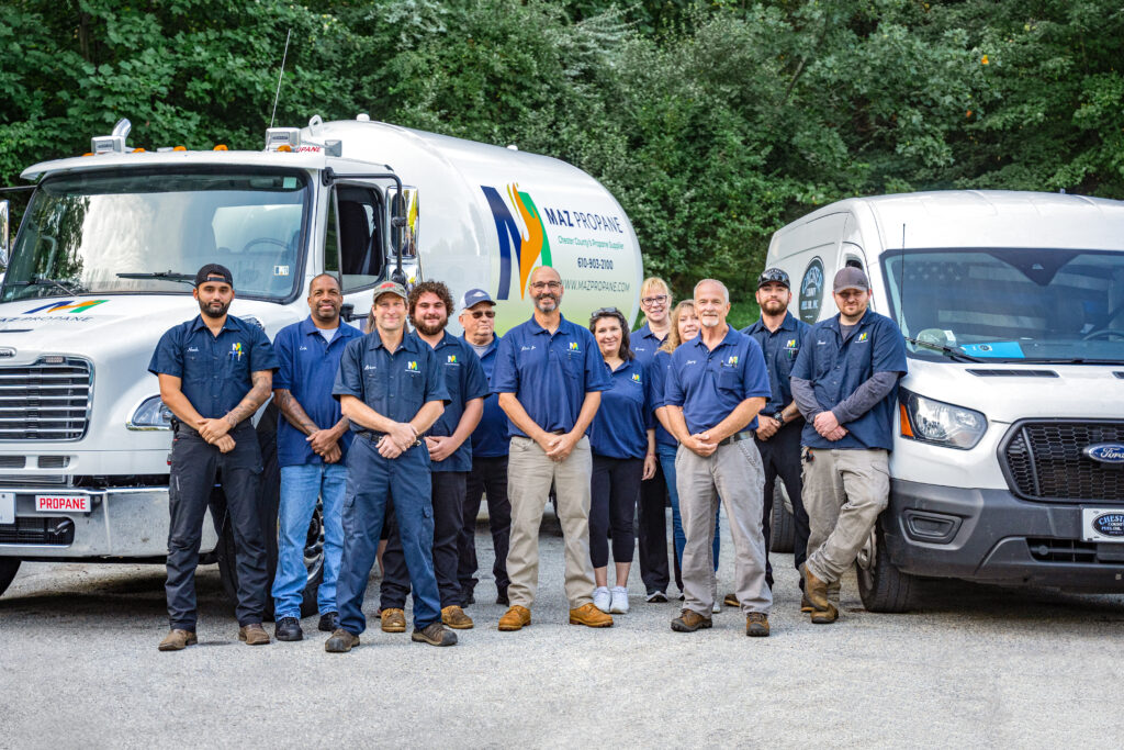 The MAZ Propane team posing in front of MAZ Propane propane delivery truck and propane service van