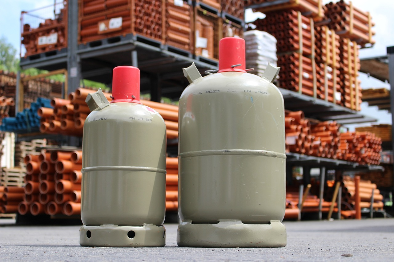 Small propane tanks infront of pipes at a hardware warehouse